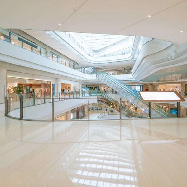 Bright shopping mall interior with glossy, reflective white epoxy flooring.